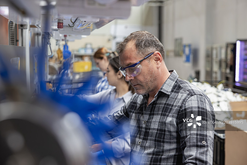 工厂生产线上的一组工人正在工作图片素材