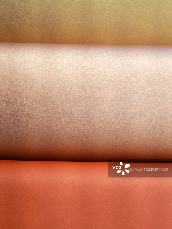 黄色、米色和棕色人造皮革的特写。图片素材