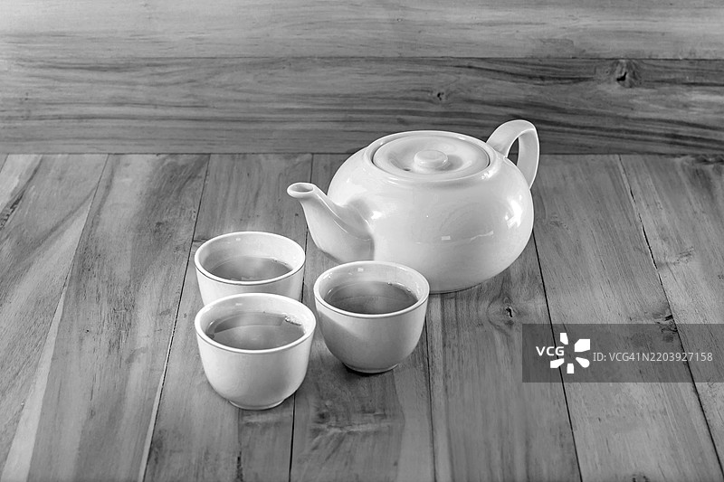 黑白色木桌上的茶杯和茶壶图片素材