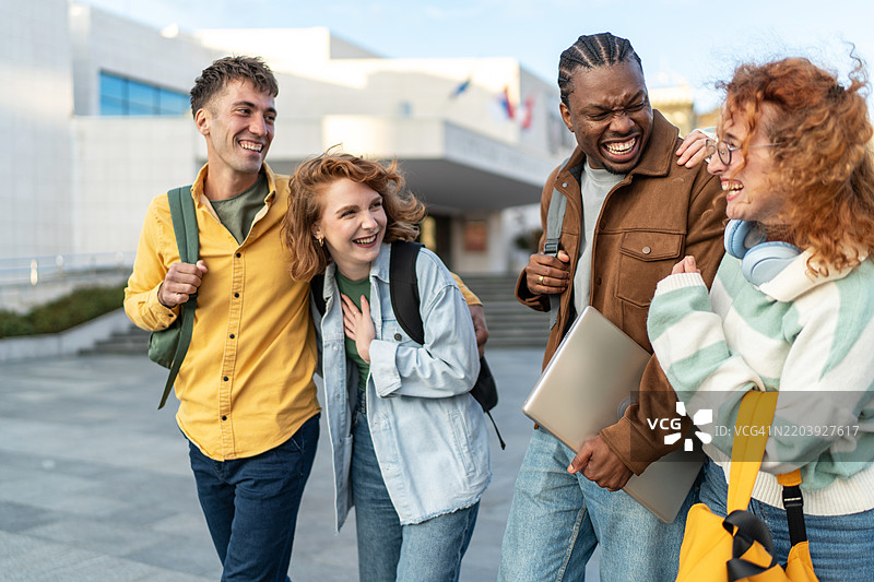 快乐的大学朋友们在上课后在城市里散步并聊天图片素材