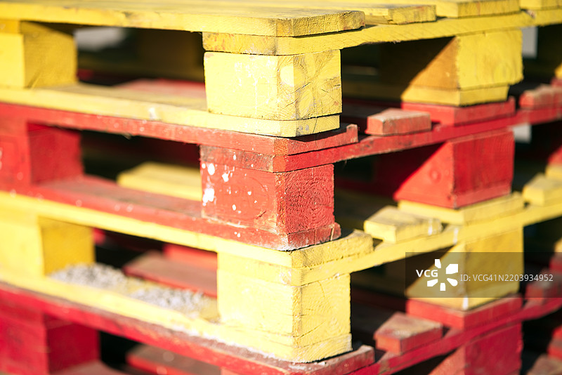 一堆涂成红色和黄色的木托盘图片素材