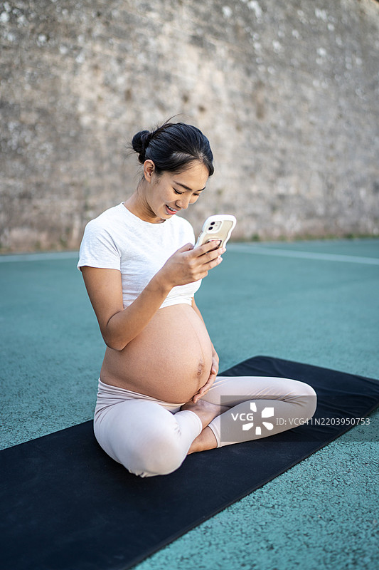美丽的孕妇在使用手机图片素材