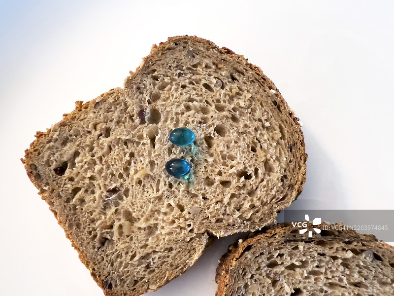 蓝色维生素D药丸放在吐司上图片素材