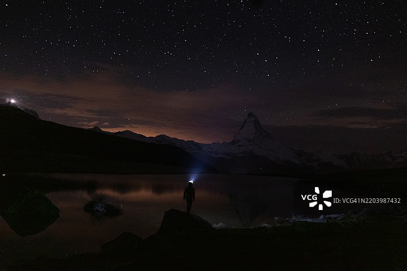 登山者用头灯照亮夜空中的山脉图片素材