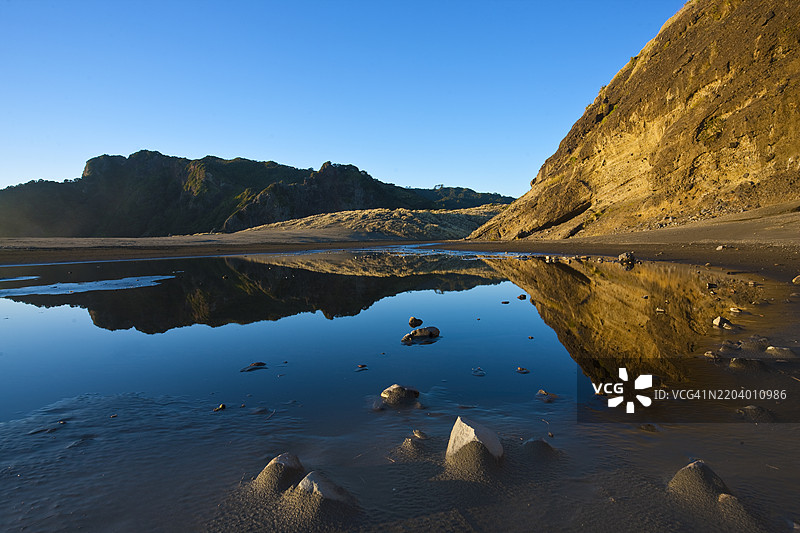 新西兰奥克兰西部的卡雷卡雷海滩，岩石 formations、黑沙滩、河流和山脉图片素材
