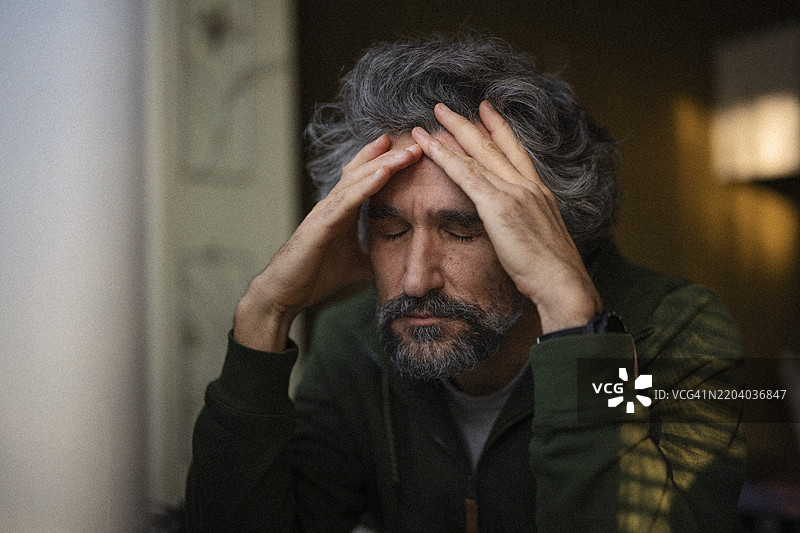 过度劳累的成熟男性双手托头冥想图片素材