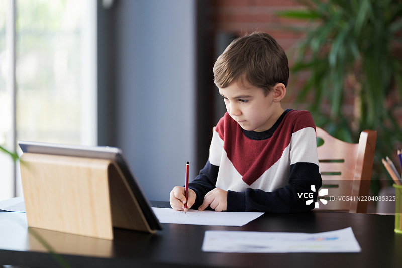 男孩在观看在线教程绘画图片图片素材