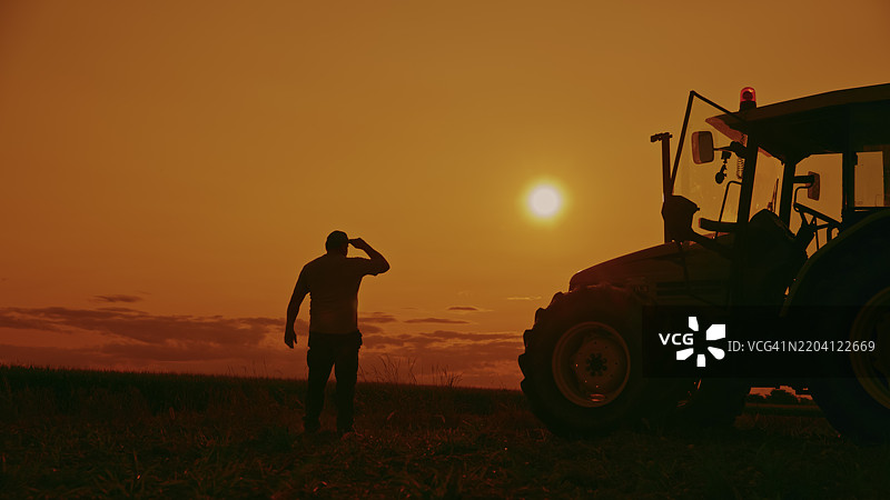 日落时分的农民与拖拉机剪影图片素材