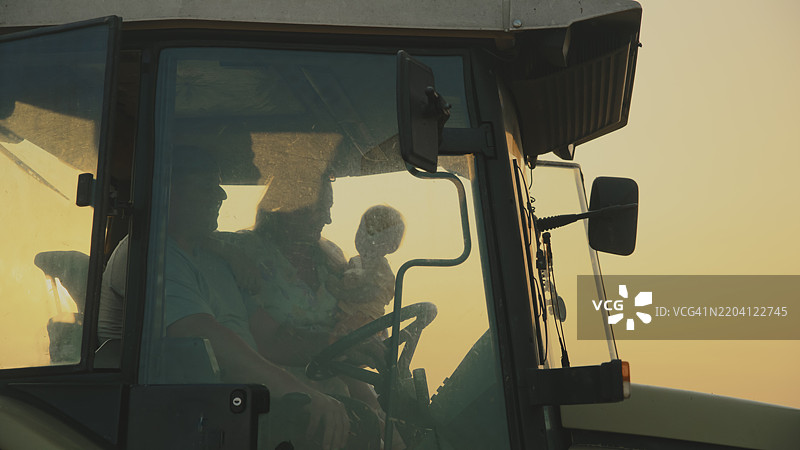 日落时分的拖拉机上的家庭图片素材
