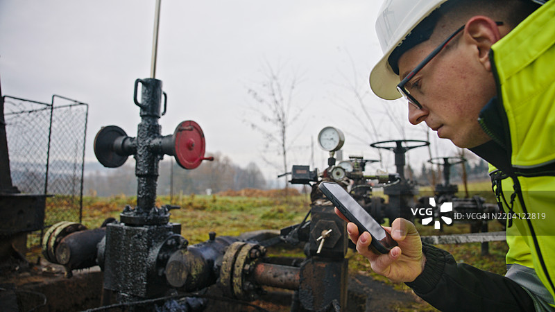 工程师在油泵现场使用手机图片素材