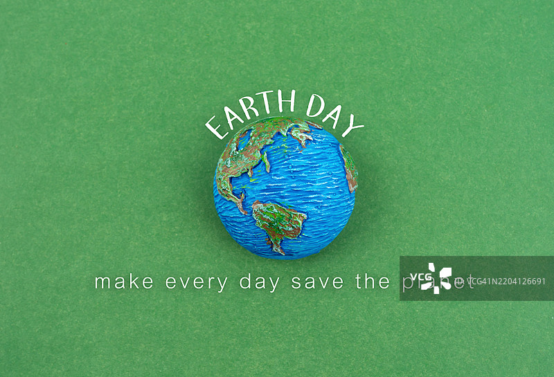 绿色背景上的地球与地球日。图片素材