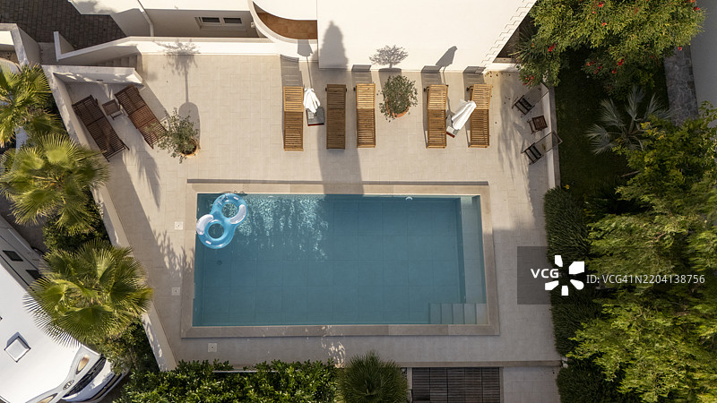 豪华户外游泳池，配有日光躺椅和热带绿植图片素材