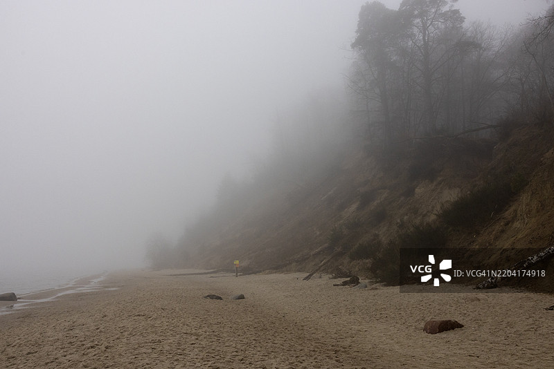 浓雾笼罩着波兰格丁尼亚的冬季海滩。图片素材