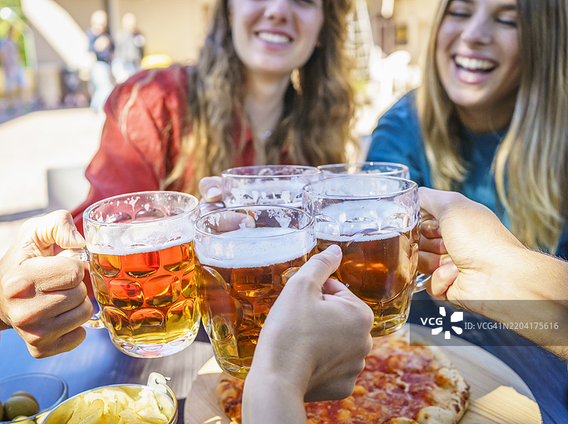 朋友们在户外聚会上举杯畅饮啤酒图片素材
