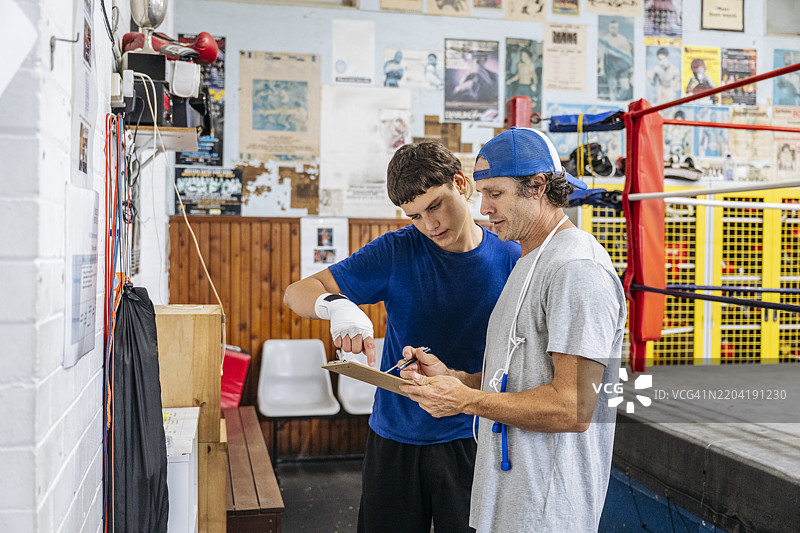 教练与年轻拳手安排训练时间图片素材