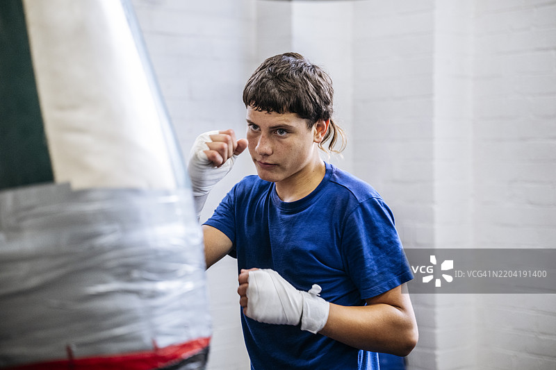 青少年拳击手在重沙袋上训练的健身肖像图片素材