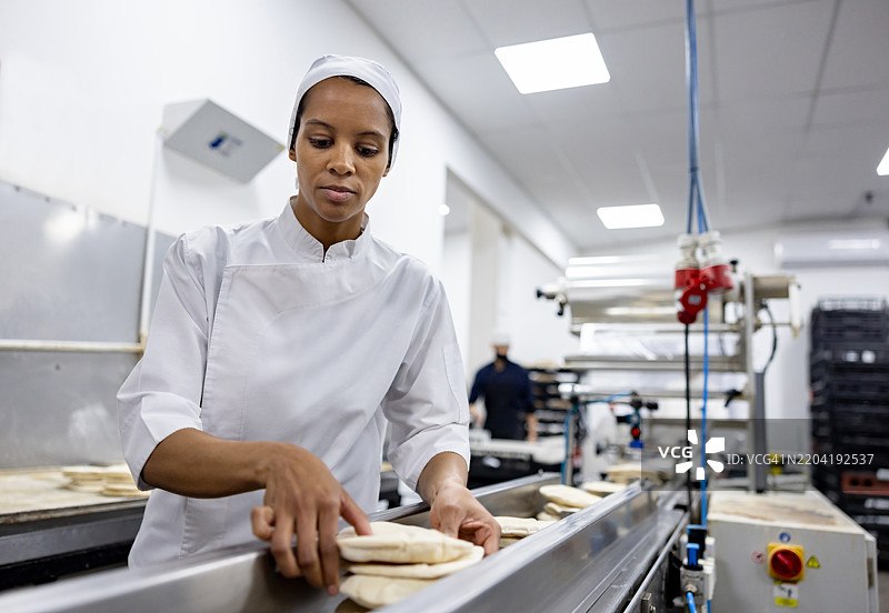 负责质量控制的工人在工业面包厂工作图片素材