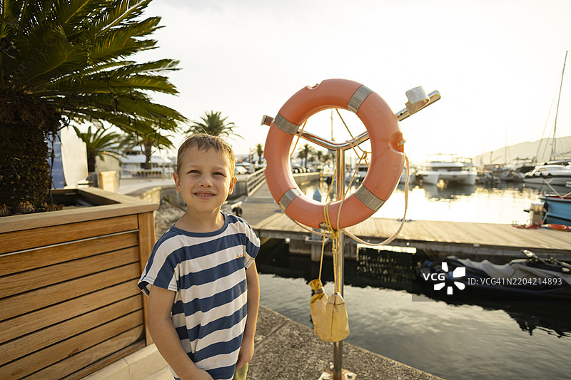 幼儿在海洋中摆姿势，手持救生圈图片素材