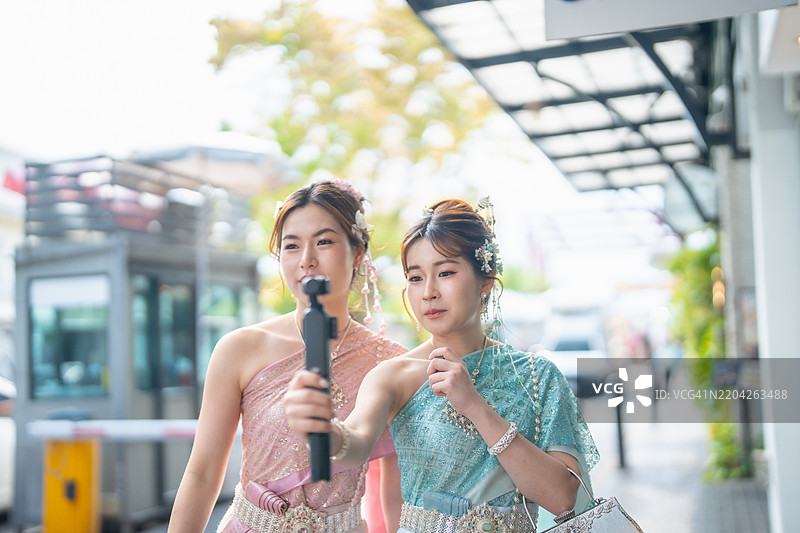 穿着传统泰国服装的亚洲旅行博主，在泰国曼谷旅游。影响者、内容创作者和YouTuber。图片素材