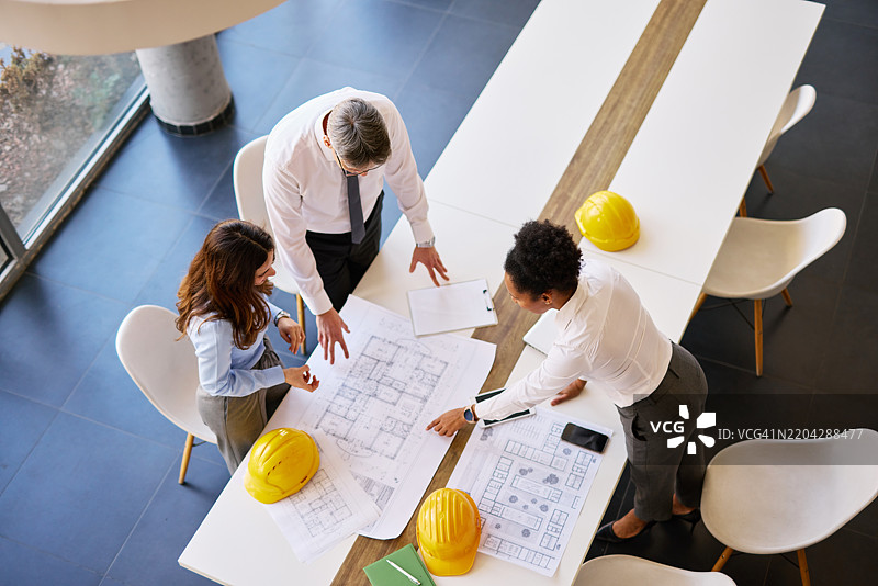 建筑师在办公室会议室分析蓝图图片素材