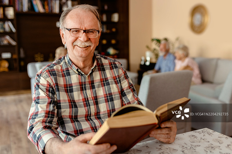 宁静时刻：退休之家中享受好书的老人图片素材