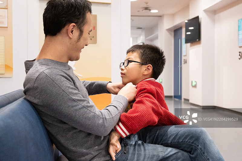 父亲和儿子在医院等待咨询图片素材