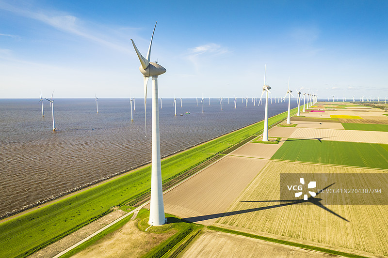 湖岸风电场的风力涡轮机在生产电力图片素材
