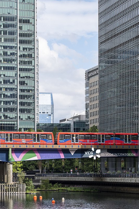 高架列车穿过金丝雀码头，映衬出城市的倒影图片素材