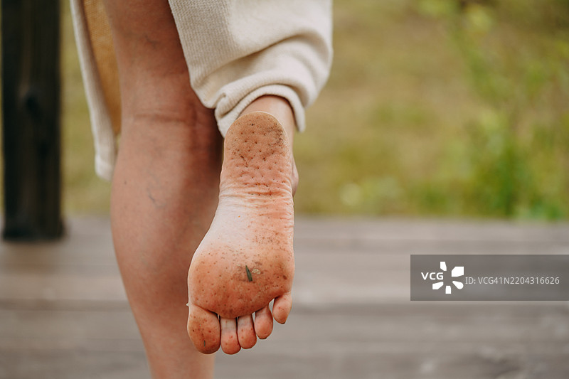 女人在户外赤脚行走后展示脏脚丫图片素材