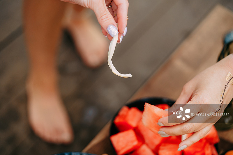 女人在野餐时吃西瓜和奶酪条图片素材