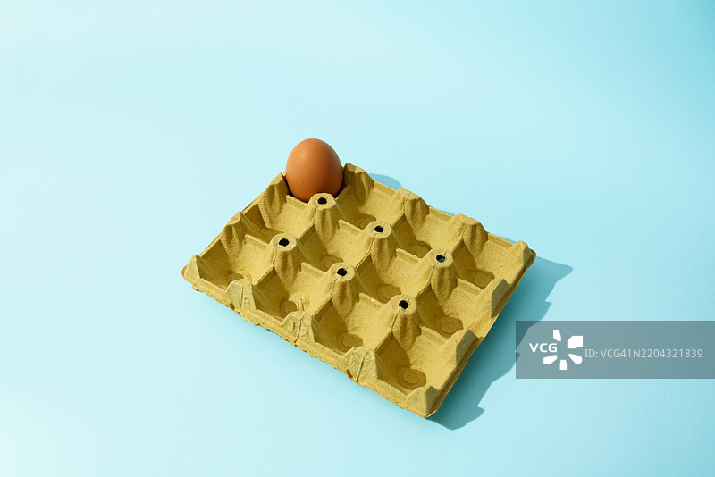 纸箱中剩下的最后一个孤独的棕色鸡蛋图片素材