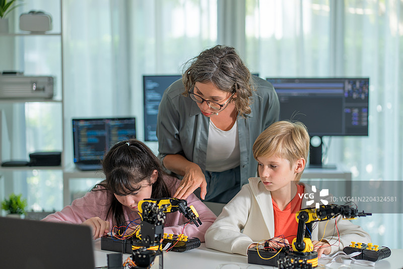 STEM教育：高中生与老师合作进行机器人项目。图片素材