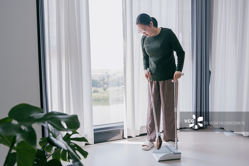 一位亚洲女性正在打扫；亚洲家庭健康管理实践图片素材