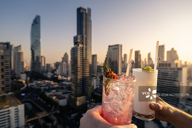 一对情侣在曼谷城市天际线前举杯畅饮图片素材