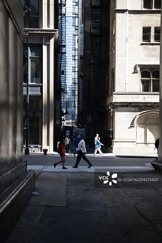 一名男子在芝加哥市中心的建筑之间走在街上图片素材