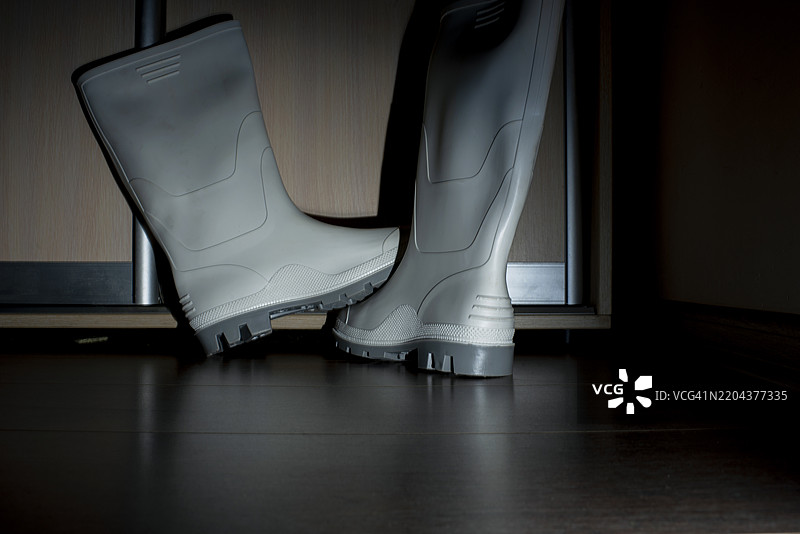 在黑色背景下的乌克兰，适合在恶劣环境中工作的白色安全橡胶靴图片素材