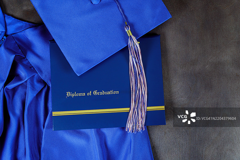 黑色背景上展示的毕业帽和文凭，象征着图片素材