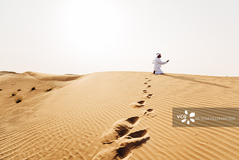 阿拉伯人在沙漠中祈祷图片素材