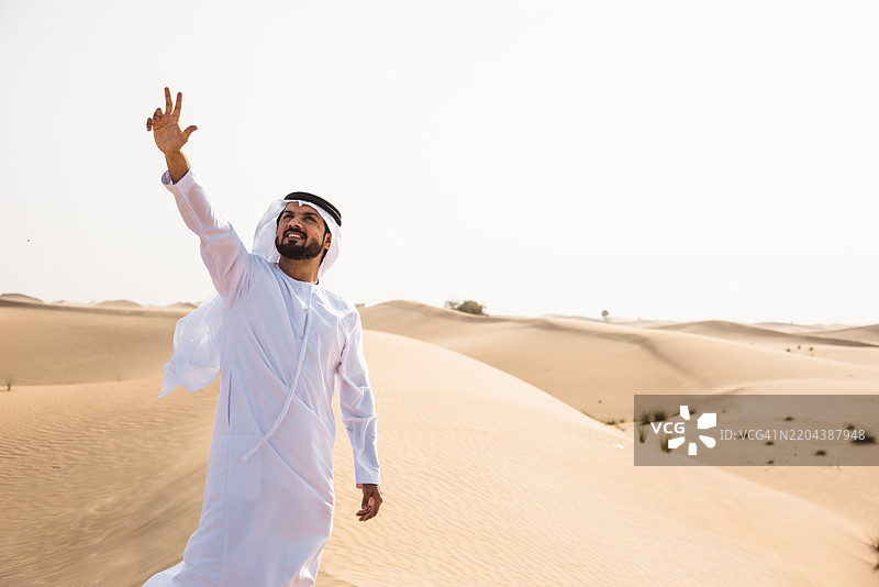 阿拉伯男子在沙漠中行走图片素材