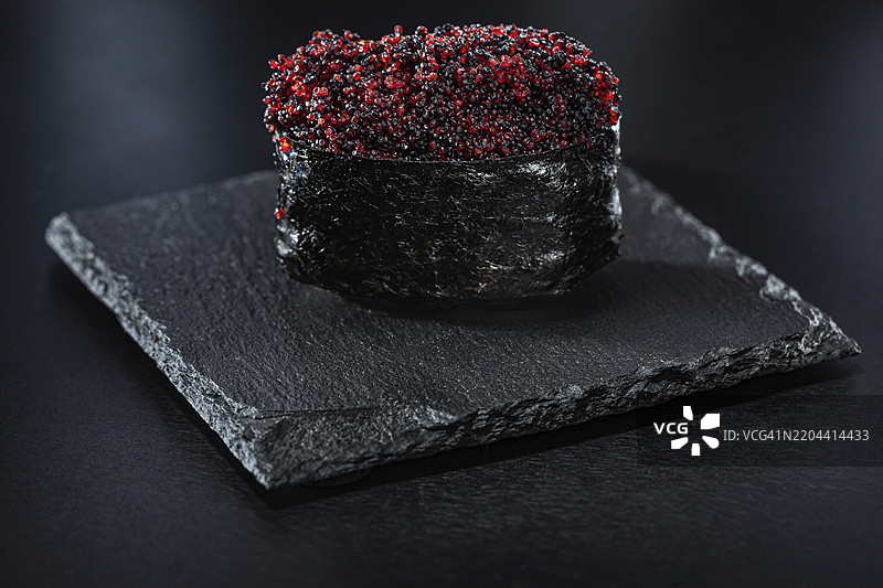 黑色石板上的鱼子酱军舰卷寿司图片素材