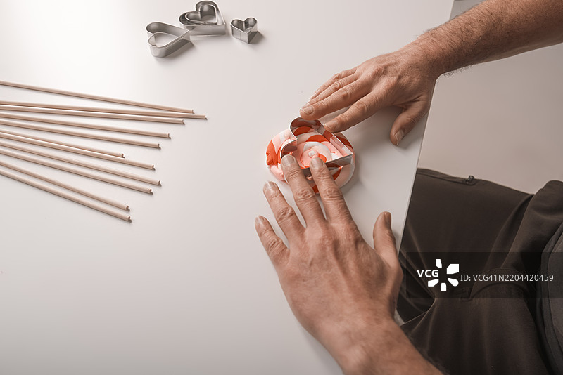 用粘土和心形模具制作情人节礼物的双手图片素材