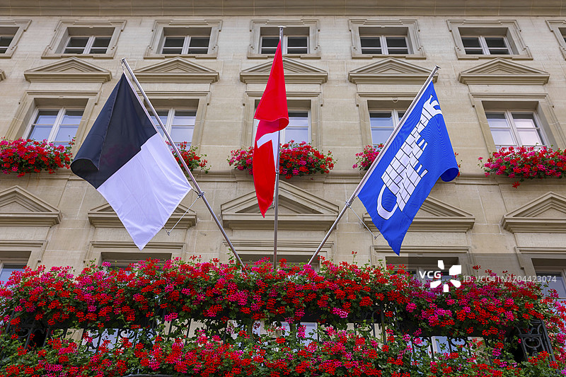 瑞士弗里堡市的市政厅，阳光明媚的夏日，旗帜和鲜花装点其间图片素材