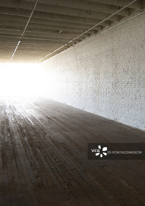 明亮的阳光照亮了一间空荡荡的老旧废弃工业建筑的房间图片素材