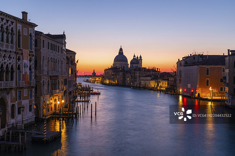 日出前的晨雾气氛,从学院桥俯瞰大运河,背景是圣玛丽亚·德拉·萨卢特大教堂,长时间曝光,意大利威尼斯,欧洲图片素材