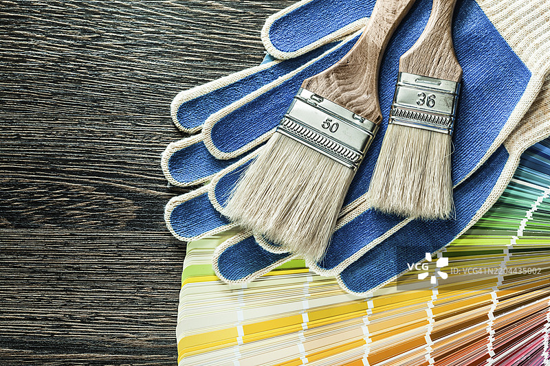 保护手套、油漆刷和潘通色卡放在木板上图片素材