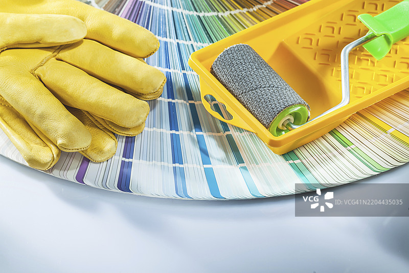 油漆滚筒托盘、安全手套、潘通色卡在白色背景上图片素材