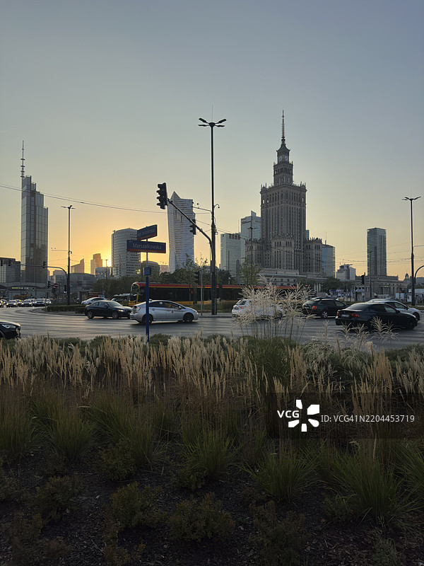 华沙 - 日落时分的文化宫与现代玻璃塔楼天际线图片素材