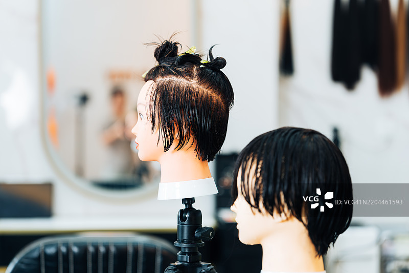 发型师培训用的模特头放在三脚架上。图片素材