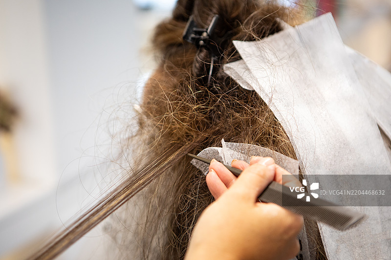 女性顾客在发廊进行头发漂白护理的特写镜头图片素材