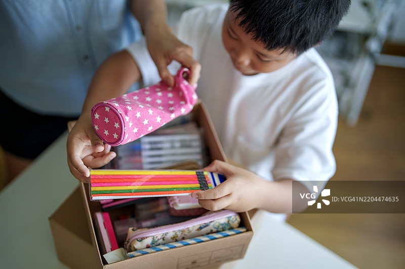 母亲和儿子整理学校用品以捐赠图片素材